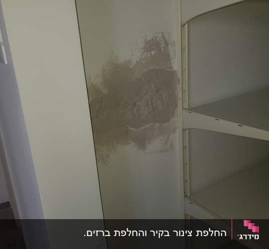 קיר עם תיקון טיח ליד מדף